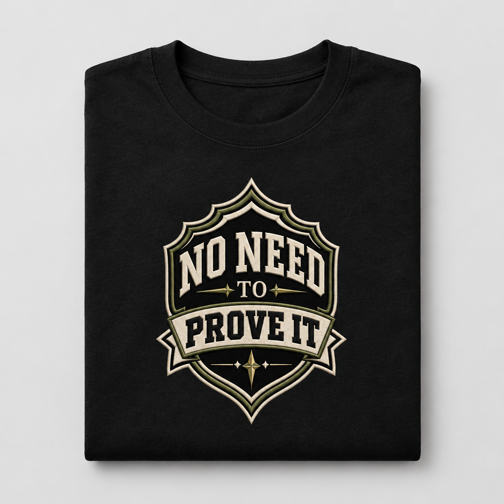 Folded black No Need to Prove It shield graphic cotton T-shirt on a light-grey background